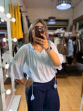 Blusa celeste con detalles de encaje y borlas